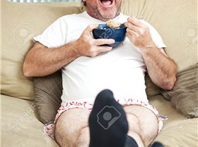 37126500-Middle-aged-man-in-his-underwea-watching-TV-and-eating-cereal-He-s-laughing-at-what-s-on-te